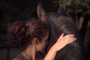 Frau kuschelt mit Pferd